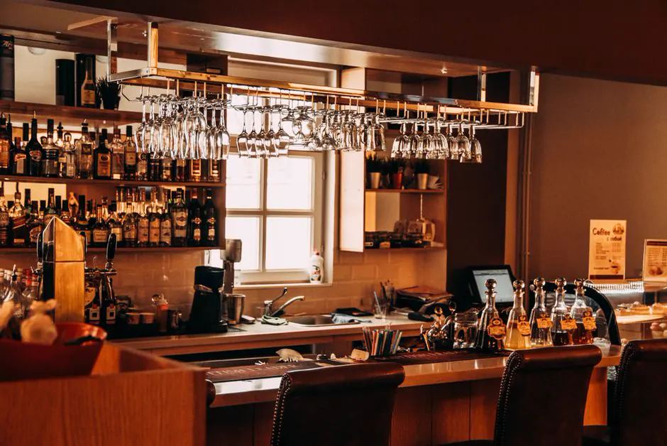 Bar counter with a wooden bar, glasses and bottles