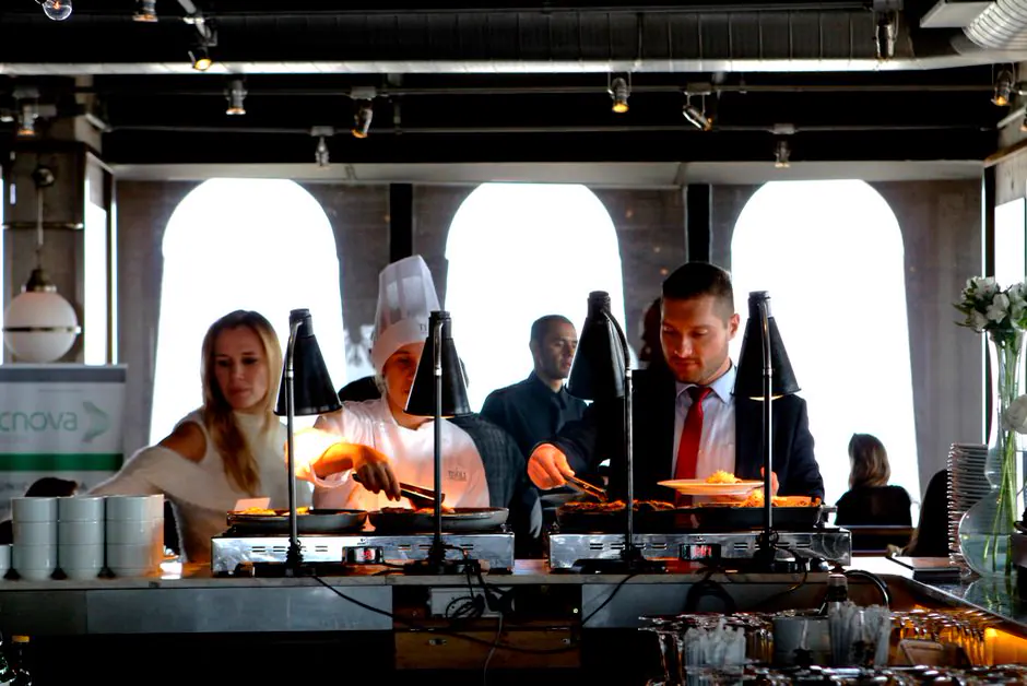 Conference participants at a buffet, a chef serving