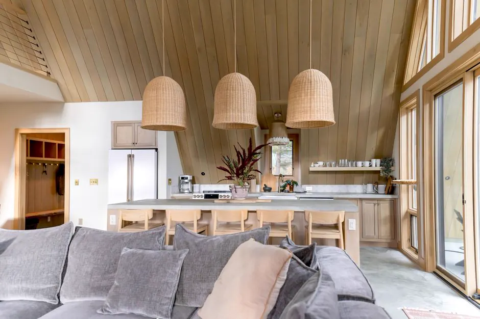 Offene Küche und Sofa in einem Ferienhaus mit Holzdecke
