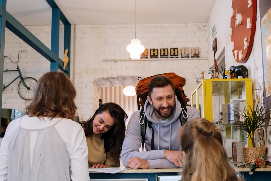 Guests with backpacks checking in at a youth hostel reception